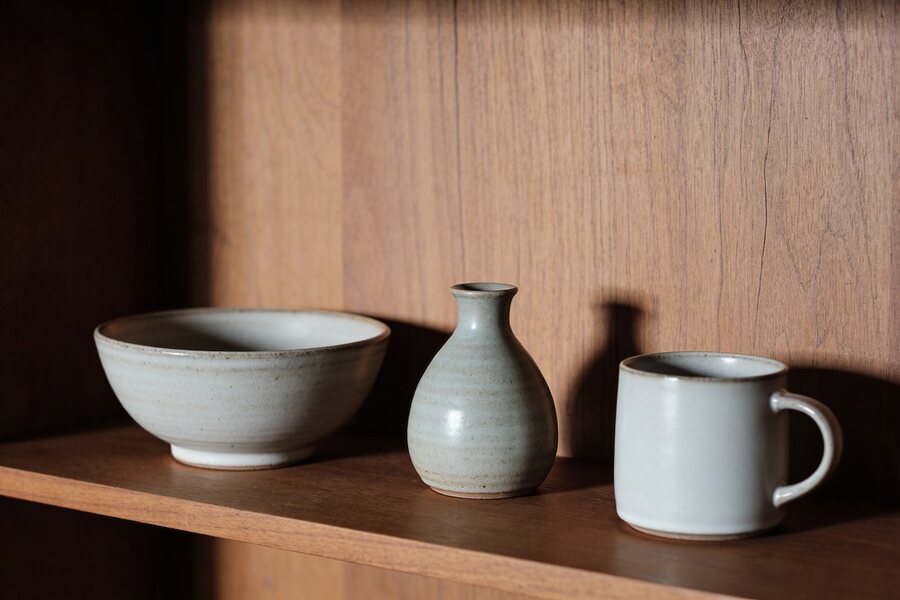 Handmade ceramic pieces on a wooden shelf